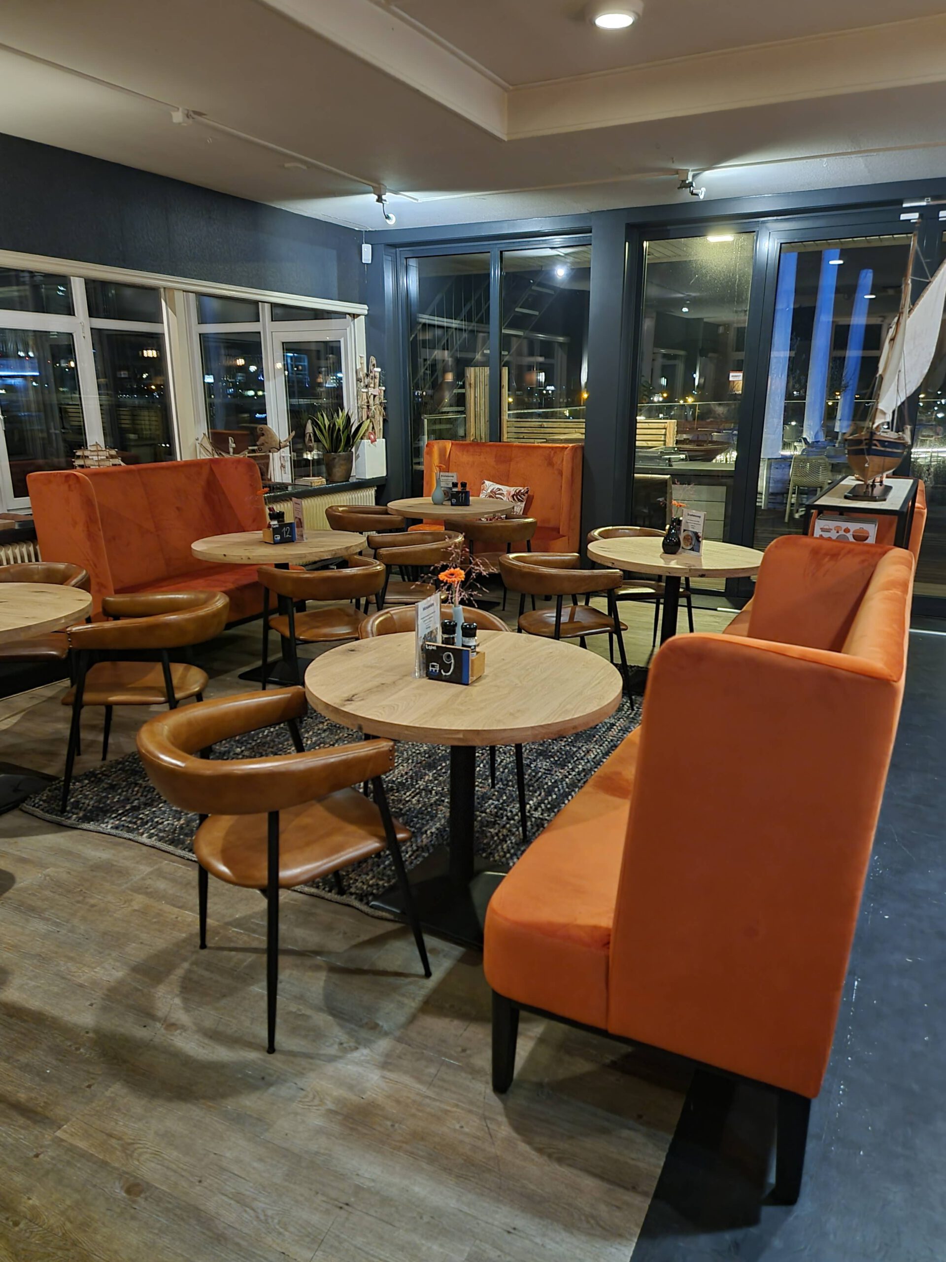 Café met oranje fauteuils en uitzicht over het water